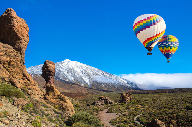 Beautiful view of unique Roque Cinchado unique rock formation with famous volcano Teide in the background on a sunny day, Teide National Park, Tenerife, Canary Islands, Spain.